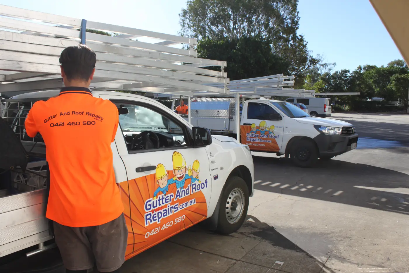 Gutter and Roof Repairs roofer standing next to company ute.