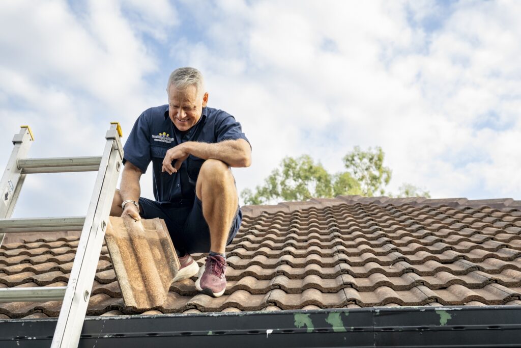 Gutter and Roof Repairs Roofer repairing a tile roof