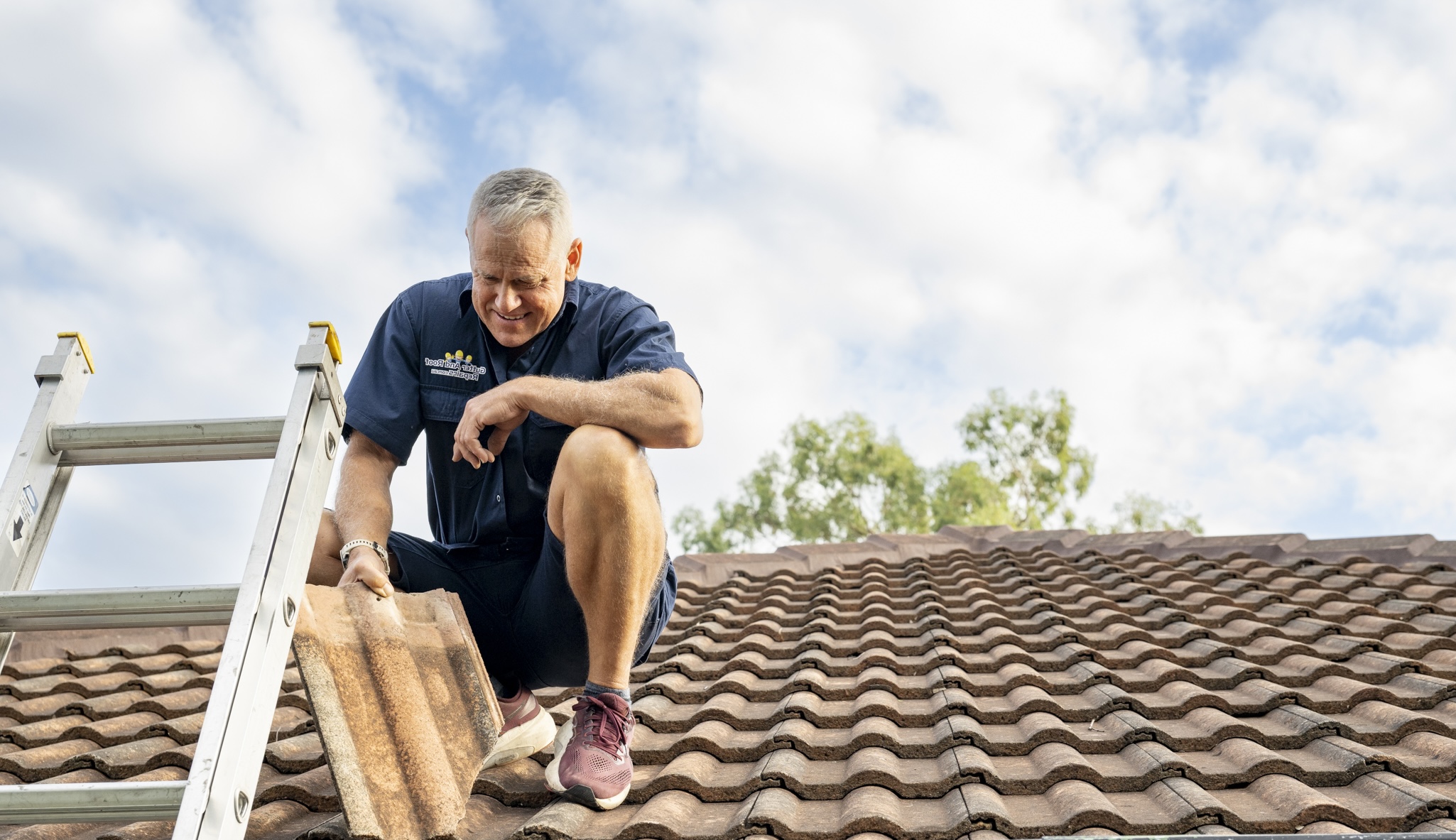Gutter and Roof Repairs roofer inspecting roof tile